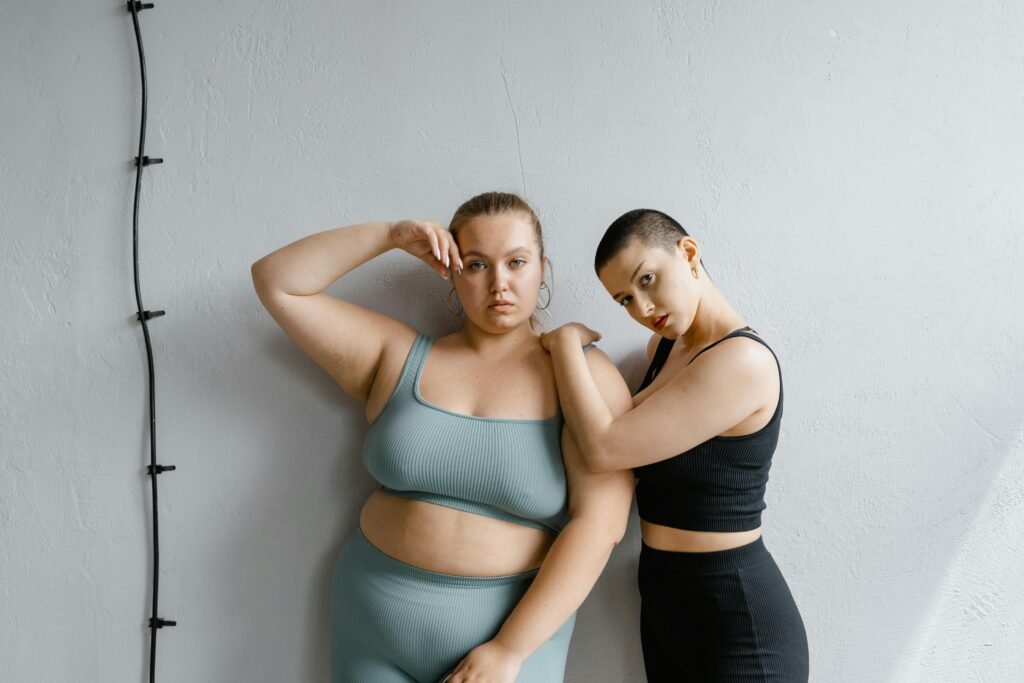 Two confident plus-size women posing stylishly against a backdrop.